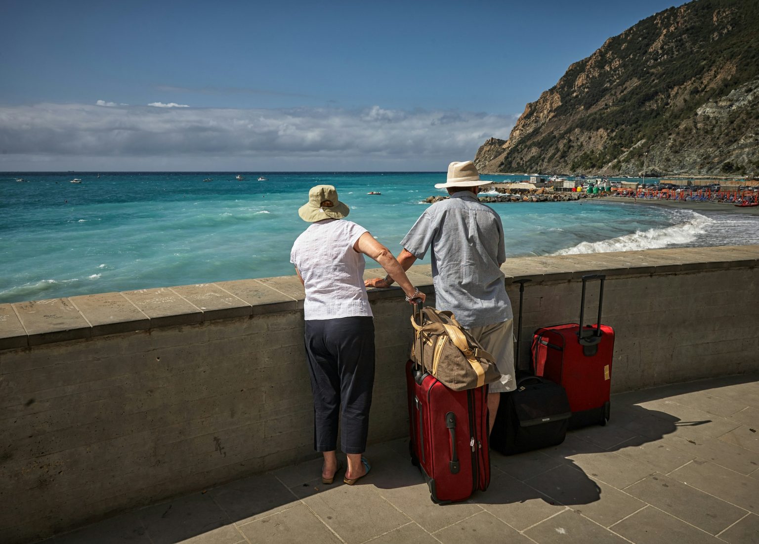 A picture of an elderly couple traveling with a bags