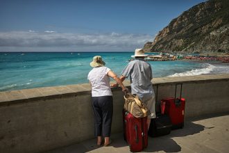 A picture of an elderly couple traveling with a bags