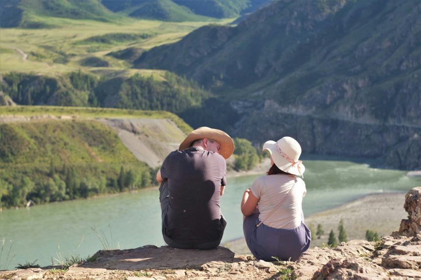 An image of a couple sitting by the beach