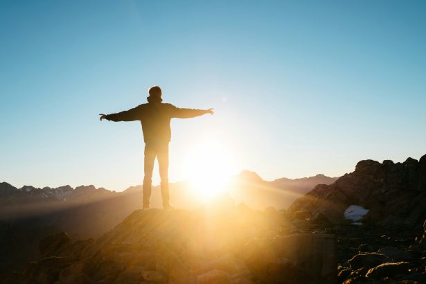 An image of a man standing outside at sunrise